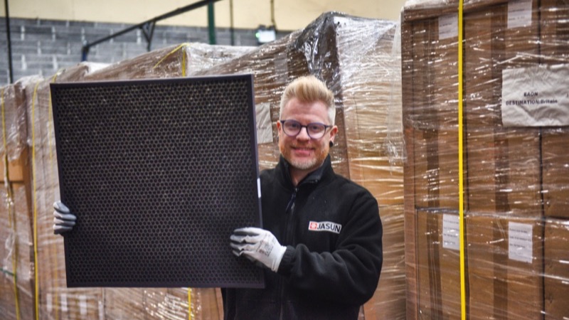 A member of the Jasun team holding a carbon panel filter in the warehouse